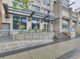 Discover modern living at this prime location featuring a sleek building facade with stone accents and large windows.