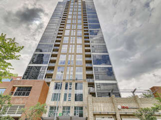 Experience modern urban living in this stunning high-rise apartment building, featuring a sleek glass facade and private balconies offering city views.