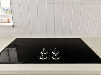 Experience modern cooking with this sleek Bosch electric cooktop, featuring intuitive controls and a stylish black glass finish.