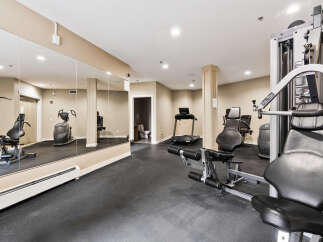 This well-equipped fitness center features a variety of cardio machines, including treadmills and ellipticals, alongside strength training equipment for a complete workout.