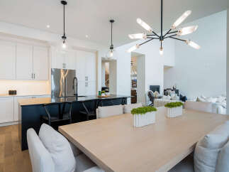 Experience modern luxury in this open-concept living space, featuring a sleek gourmet kitchen with a waterfall island and stainless steel appliances.
