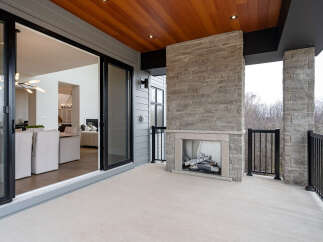 Experience seamless indoor-outdoor living with this stunning covered patio, featuring a modern stone fireplace perfect for cozy evenings.
