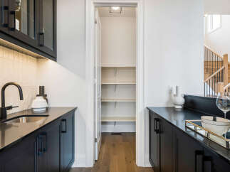 Discover modern living with this sleek wet bar featuring dark cabinetry and a stylish black faucet.