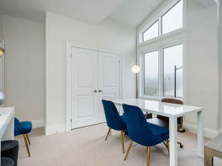 This bright and airy home office features a sleek white desk paired with plush navy velvet chairs, perfect for productive work sessions.
