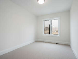 Discover this bright and airy bedroom, featuring a neutral color palette and plush carpeting for ultimate comfort.