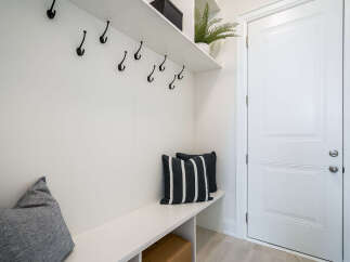This mudroom features a built-in bench with storage, perfect for stowing away shoes and bags.