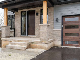 Discover modern living with this stunning home featuring a welcoming porch and a sleek garage door.