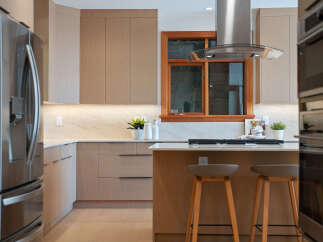 Experience modern luxury in this stunning kitchen, featuring sleek, light wood cabinetry and a spacious island perfect for entertaining.