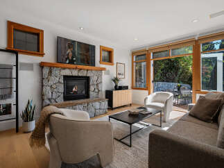 Experience modern living in this beautifully appointed living room, featuring a striking stone fireplace as the centerpiece.