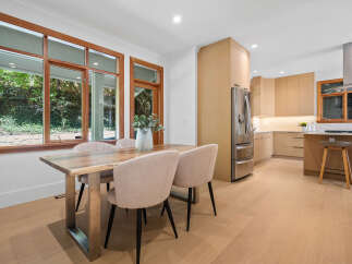 Experience modern living in this stunning kitchen and dining area, featuring sleek light wood cabinetry and a spacious island perfect for entertaining.