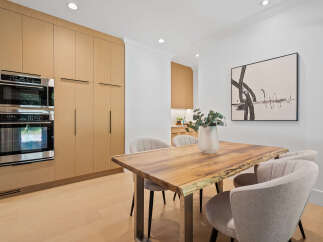 Experience modern living in this stunning dining area, featuring sleek, integrated cabinetry and high-end stainless steel appliances.