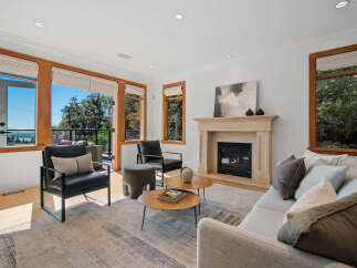 Experience modern living in this bright and airy living room, featuring a cozy fireplace and large windows that offer stunning views.