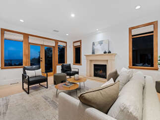 Experience modern living in this beautifully appointed living room, featuring a cozy fireplace and large windows that offer stunning views.