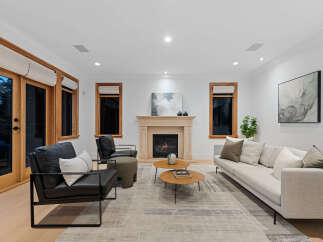 Experience modern living in this stunning living room, featuring a cozy fireplace and elegant artwork.