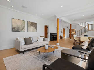 Experience modern living in this spacious open-concept home featuring a stylish living area with a comfortable sofa and abstract art.