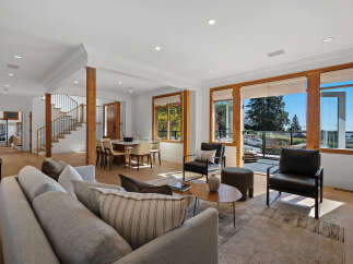 Experience modern living in this spacious open-concept home, featuring a bright living area with large windows offering scenic views.
