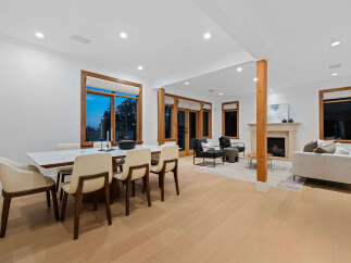 Experience modern living in this spacious open-concept home, featuring a sleek dining area with a white table and comfortable chairs, perfect for family gatherings.