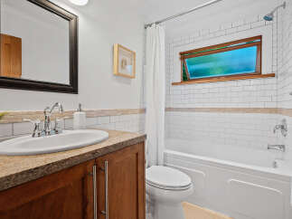 This charming bathroom features a spacious vanity with a granite countertop and a deep basin sink, perfect for your morning routine.