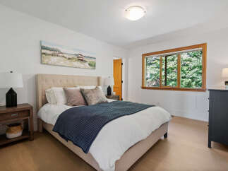 Experience tranquility in this serene bedroom, featuring a plush tufted headboard and a calming blue throw.