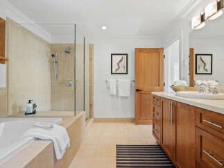 This luxurious bathroom features a spacious soaking tub and a separate glass-enclosed shower with elegant tilework.