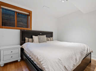 This bedroom features a comfortable king-size bed with a dark wood headboard and plush white bedding.
