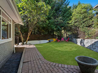 Enjoy outdoor living in this spacious backyard featuring a lush green lawn, perfect for recreation and relaxation.