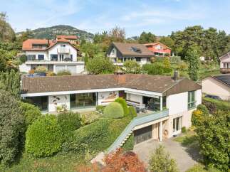 Nestled on a lush hillside, this property offers stunning panoramic views and a serene living environment.