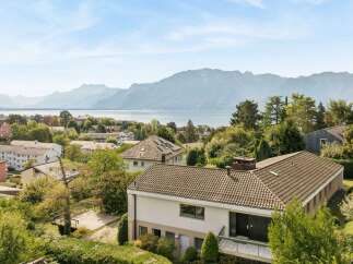 Experience breathtaking panoramic views of a serene lake and majestic mountains from this stunning property.