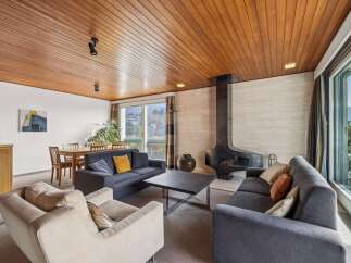 Experience modern living in this spacious living room featuring a striking black fireplace as the centerpiece.