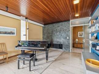 Experience elegant living in this spacious room featuring a grand piano, perfect for music enthusiasts.