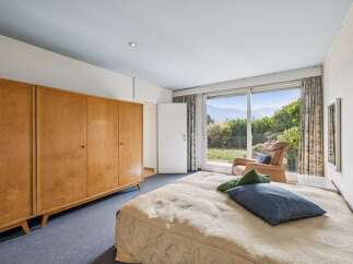 This spacious bedroom offers a large wooden wardrobe and a comfortable bed, perfect for relaxation.