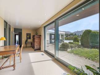 Experience seamless indoor-outdoor living with expansive sliding glass doors that open to a lush garden and stunning mountain views.