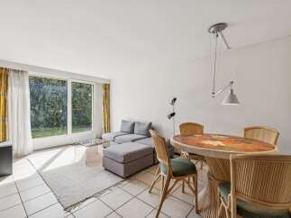 Bright and airy living and dining area featuring a comfortable sectional sofa and a charming dining set.