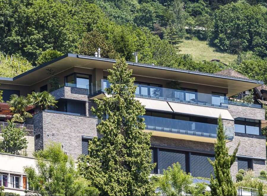 Experience modern luxury in this stunning hillside residence, featuring expansive glass balconies with breathtaking views.