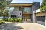 Experience modern luxury in this stunning home featuring a striking stone facade and expansive glass windows that invite natural light.