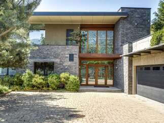 Experience modern luxury in this stunning home featuring a striking stone facade and expansive glass windows that invite natural light.