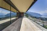 Experience breathtaking panoramic views from this expansive modern balcony, featuring floor-to-ceiling glass walls that seamlessly blend indoor and outdoor living.