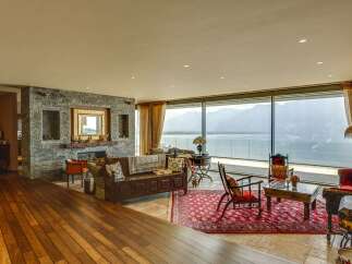 Experience breathtaking panoramic views of mountains and water from this stunning living room.