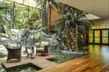 Experience luxurious indoor-outdoor living with this stunning atrium featuring a tranquil koi pond and lush tropical plants.