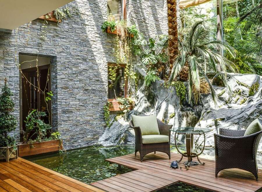 Experience tranquility in this stunning indoor oasis, featuring a serene koi pond and a lush, tropical garden.