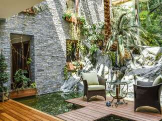 Experience tranquility in this stunning indoor oasis, featuring a serene koi pond and a lush, tropical garden.
