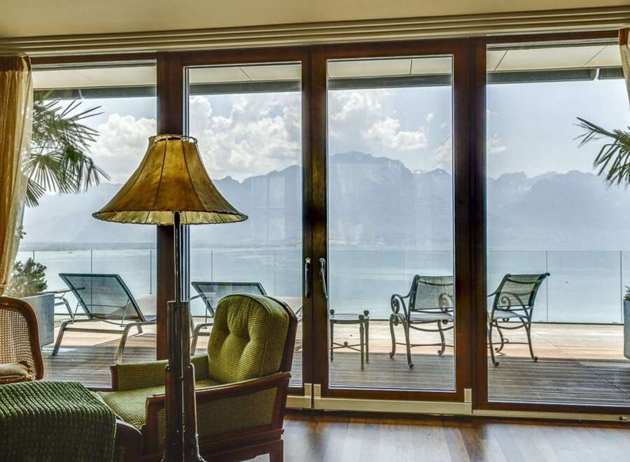 Experience breathtaking mountain and lake views from this stunning property, featuring expansive glass doors that open onto a private deck.