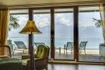 Experience breathtaking mountain and lake views from this stunning property, featuring expansive glass doors that open onto a private deck.