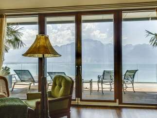 Experience breathtaking mountain and lake views from this stunning property, featuring expansive glass doors that open onto a private deck.