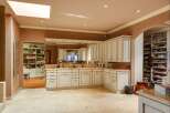 Discover this expansive walk-in closet and dressing room, featuring custom cabinetry and ample shelving for organized storage.