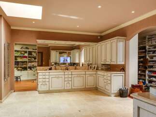 Discover this expansive walk-in closet and dressing room, featuring custom cabinetry and ample shelving for organized storage.