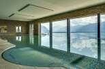 Experience luxury living with this stunning indoor swimming pool, featuring breathtaking panoramic views of majestic mountains and a serene lake.