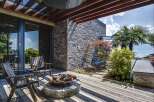 Experience luxurious outdoor living with this stunning deck featuring comfortable seating and a rustic fire pit, perfect for evening gatherings.