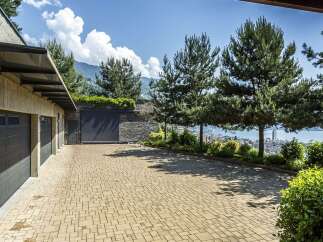 Experience luxury living with this stunning property featuring a spacious driveway leading to multiple garage doors.