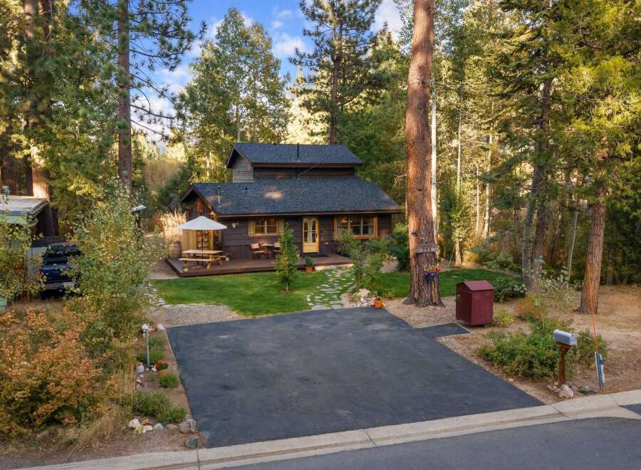 Nestled amidst towering pines, this charming cabin offers a serene retreat with a spacious deck perfect for outdoor dining and relaxation.